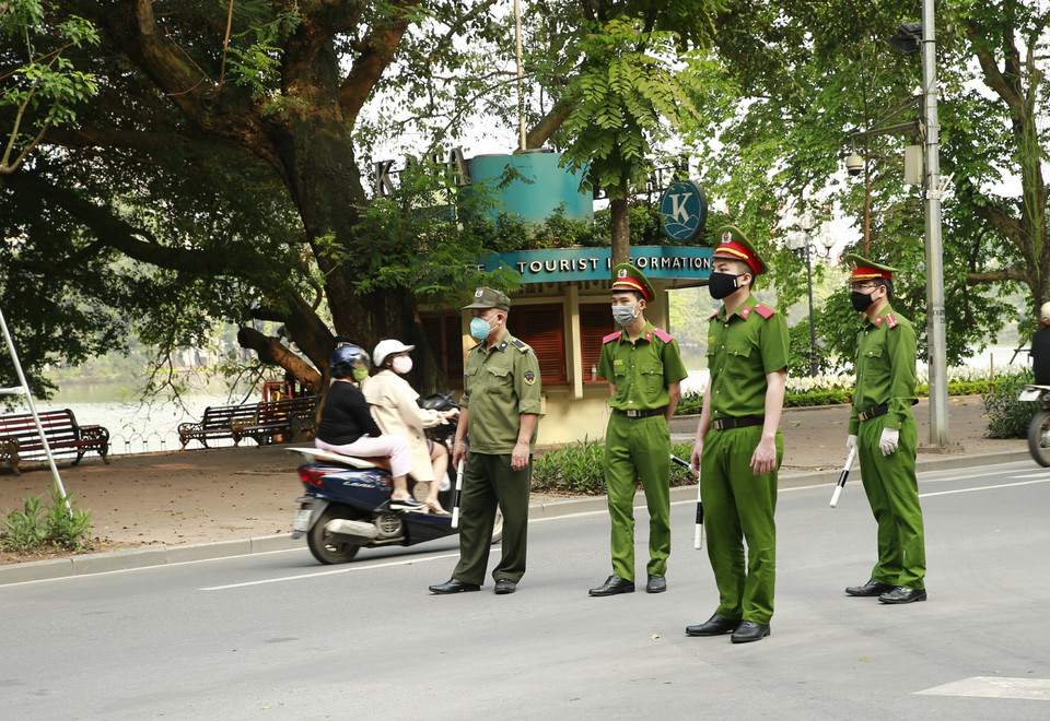 Công an quận Hoàn Kiếm lập chốt, tuyên truyền người dân ở nhà, hạn chế tối đa ra ngoài tập thể dục tại khu vực Hồ Hoàn Kiếm. (Ảnh: Doãn Tấn/TTXVN)