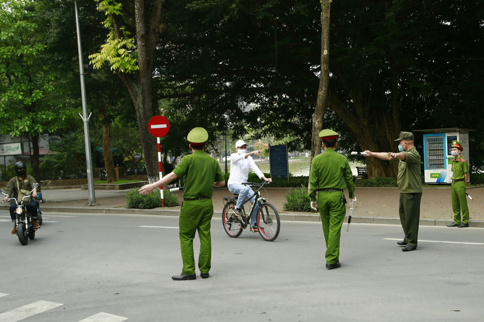 Công an quận Hoàn Kiếm lập chốt, tuyên truyền người dân ở nhà, hạn chế tối đa ra ngoài tập thể dục tại khu vực Hồ Hoàn Kiếm. (Ảnh: Doãn Tấn/TTXVN)