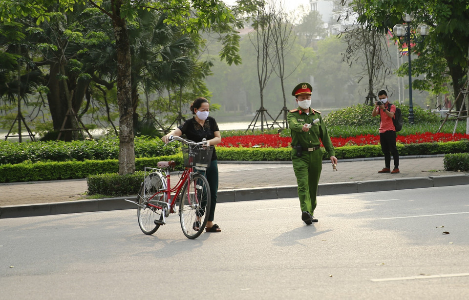 Công an quận Hoàn Kiếm lập chốt, yêu cầu người dân ở nhà, hạn chế tối đa ra ngoài tập thể dục tại khu vực Hồ Hoàn Kiếm. (Ảnh: Doãn Tấn/TTXVN)