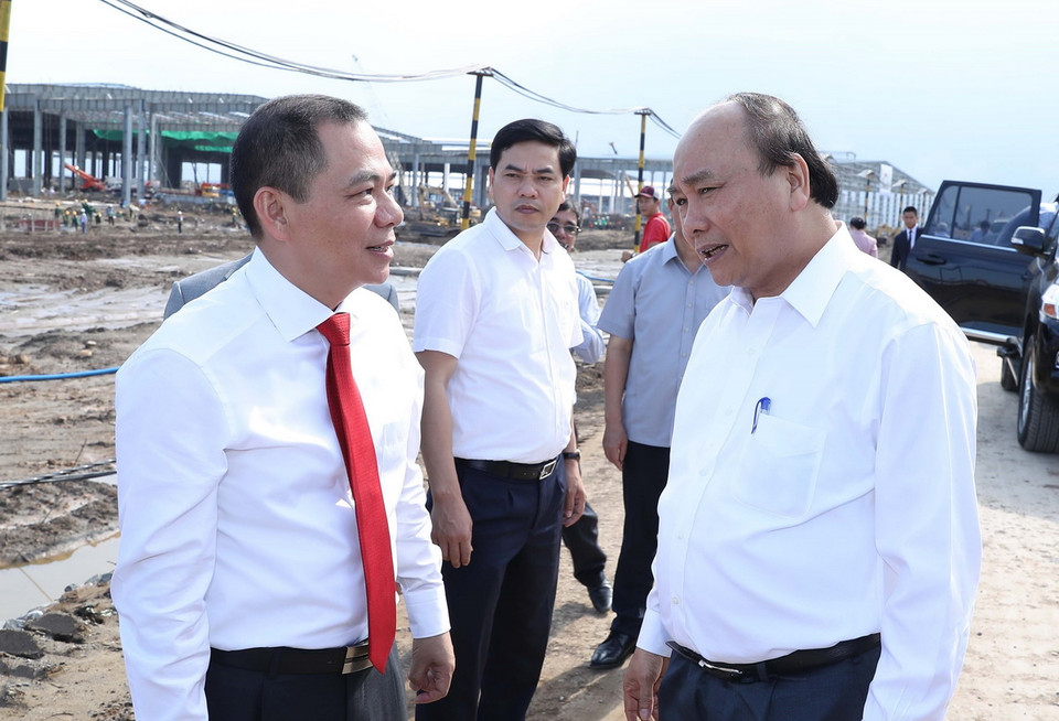 Thủ tướng Nguyễn Xuân Phúc trao đổi với ông Phạm Nhật Vượng, Chủ tịch Hội đồng quản trị Tập đoàn Vingroup tại khu vực hạng mục đang được xây dựng của Nhà máy ôtô Vinfast. (Ảnh: Thống Nhất/TTXVN)