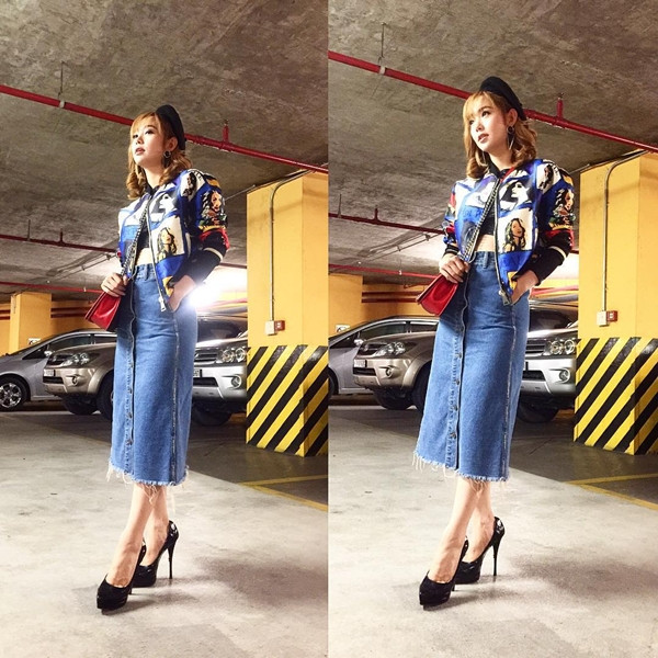 Minh Hằng phá cách với trang phục áo lửng (crop-top) phối cùng áo khoác thể thao (bomber) họa tiết bắt mắt và chân váy denim cổ điển. Nữ ca sỹ 'chơi trội' với mũ nồi và giày cao gót tuyền đen mang cảm hứng retro.