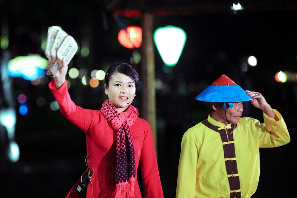 Chị hiệu chia bộ bài ra làm đôi: một nửa bỏ vào ống do người hô hiệu giữ, một nửa đem phân phối cho 9 chòi, mỗi chòi 3 lá. (Ảnh: Trọng Đạt/TTXVN)