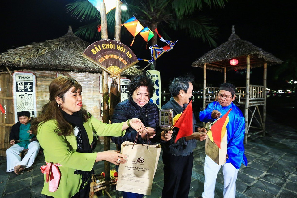 Du khách là người thắng cuộc sẽ nhận quà lưu niệm khi có 3 lá bài trùng khớp với 3 trong số những lá bài “anh hiệu, chị hiệu” hô hát trong một ván chơi Bài Chòi. (Ảnh: Trọng Đạt/TTXVN)