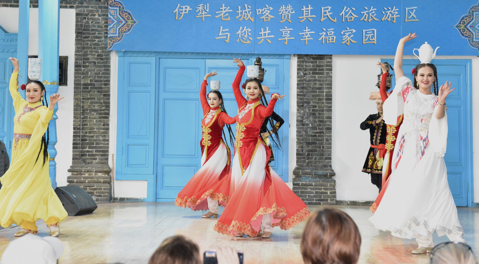 Những cô gái, chàng trai dân tộc thiểu số đội bát và ấm trà trên đầu nhảy múa khi có khách quý đến chơi. (Ảnh: Quang Hưng/TTXVN)