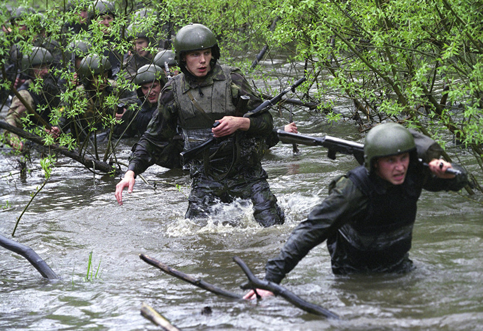 Đầu tiên, một người lính phải vác vũ khí đi quãng đường dài 12km cùng với người huấn luyện. (Nguồn: Sputniknews)