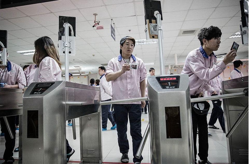 Công nhân quẹt thẻ vào khu sản xuất. (Nguồn: Bloomberg)