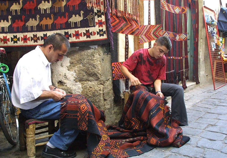 Hai người thợ đang dệt thảm ở chợ Damascus. (Nguồn: Sputniknews)