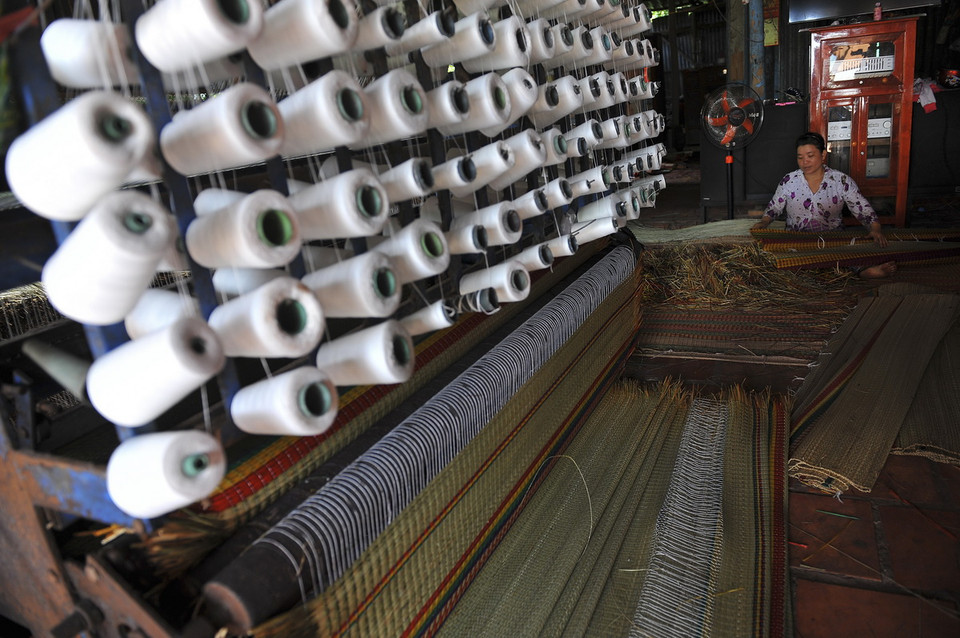 Đến Định Yên, du khách sẽ cảm nhận thấy không khí làm việc của người dân rất nhộn nhịp. Nhờ áp dụng máy móc vào sản xuất, chủ động tìm đầu ra cho sản phẩm, làng nghề dệt chiếu Định Yên đang trở lại thời hoàng kim. (Ảnh: Minh Đức/TTXVN)