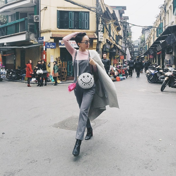 Trở thành 'ngôi sao' đường phố với áo thun hồng và quần yếm dài kẻ sọc, Tóc Tiên còn thu hút công chúng bởi cách sử dụng túi đeo tròn mặt cười làm phụ kiện chấm phá.