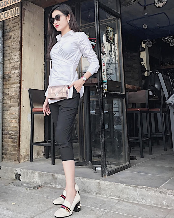 Vẫn là sơmi trắng, nhưng Huyền My đã làm bật nét thanh lịch, thời thượng nhờ cách kết hợp món đồ quen thuộc này với quần bermuda đen, giày Gucci và túi Dior 'đắt giá.'