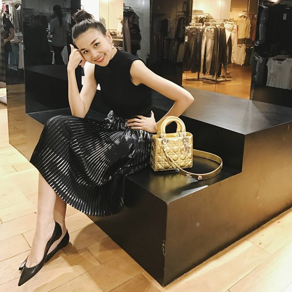 Thanh Hằng vẫn trung thành với phong cách tối giản. Song để làm mới cho bộ cánh tuyền đen, siêu mẫu khéo chọn chân váy chất liệu ánh kim, dùng túi xách gam màu vàng metallic làm phụ kiện 'thắp sáng' tổng thể trang phục.