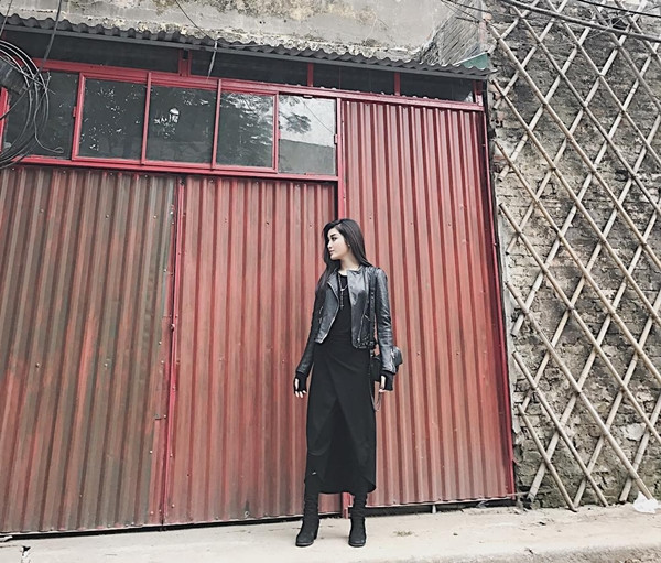 Á hậu Việt Nam 2014 hết mực cá tính khi mix trang phục theo công thức 'đen toàn tập' (all black). Người đẹp kết hợp lạ mắt skinny với đầm quấn, phối ngoài là áo khoác da, không quên mang phụ kiện túi, boots tuyền đen để tạo sự thống nhất.