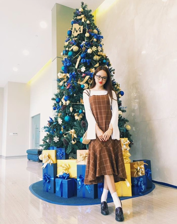 Hương Giang Idol cũng không bỏ qua 'combo' duyên dáng khi chọn đầm 2 dây kẻ ô vuông gam màu trầm, bắt cặp cùng áo tay loe tuyền trắng. Mỹ nhân chuyển giới còn tô đậm nét nữ tính bằng lối kết hợp giày xỏ và tất cao cổ theo phong cách preppy.