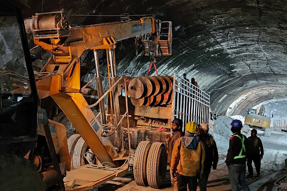 Lực lượng chức năng tập trung khoan xuyên qua một tảng đá rơi để lắp đặt một đường ống có thể đưa các nạn nhân bị mắc kẹt trong vụ sập đường hầm ở bang Uttarakhand, miền Bắc Ấn Độ, ra ngoài an toàn. (Ảnh: AFP/TTXVN)