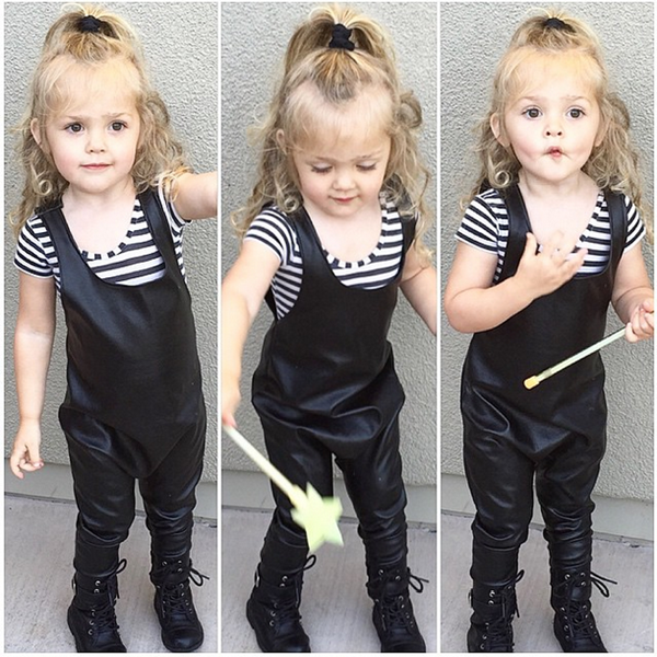 Daisy Lou xinh như búp bê với mái tóc vàng xoăn nhẹ buộc chỏm cao khi điệu đà với bộ jumpsuit (bộ đồ liền) màu đen giả da.