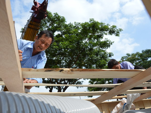 Vỏ Chú Vịt Vàng nhanh chóng được đưa ra khỏi thùng gỗ... (Ảnh: Sỹ Dũng/Vietnam+)