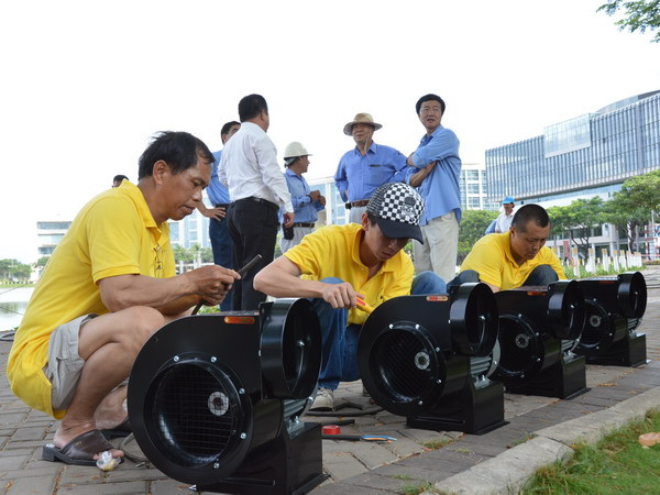 Các chuyên gia đến từ Đài Loan kiểm tra máy bơm hơi, chuẩn bị cho việc thổi căng Chú Vịt Vàng. (Ảnh: Sỹ Dũng/Vietnam+)