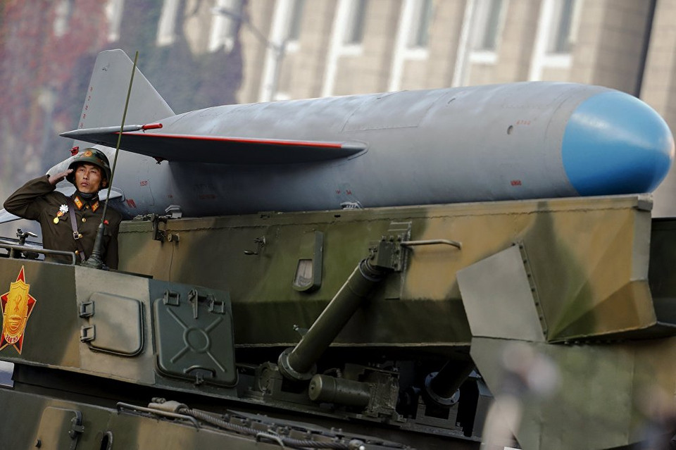 Người lính đứng chào cờ trên xe diễu hành mang tên lửa. (Nguồn: Sputniknews)