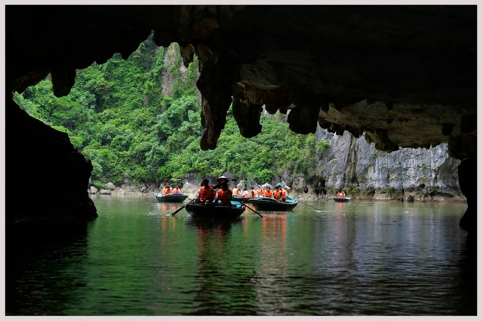 Du khách khám phá hang động trên Vịnh Hạ Long. (Ảnh: Thanh Hà/TTXVN)