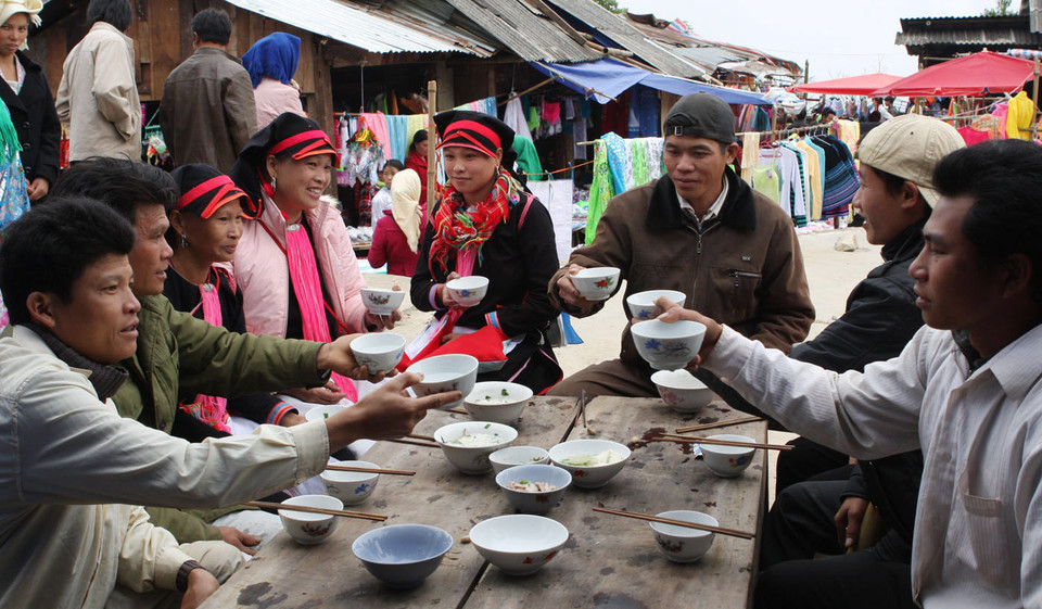 Xuống chợ và cùng nhau uống chén rượu là một nét đặc trưng tại chợ phiên. (Ảnh: Trần Việt/TTXVN)
