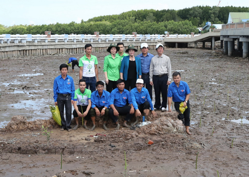 Chủ tịch Quốc hội Nguyễn Thị Kim Ngân và các đoàn viên thanh niên tham gia trồng cây ở xóm Mũi xã Đất Mũi. (Ảnh: Trọng Đức/TTXVN)