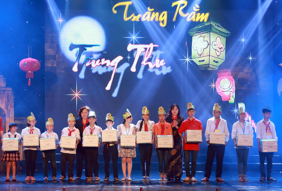 Các tập thể, cơ quan trao học bổng cho các em có hoàn cảnh khó khăn vươn lên trong học tập. (Ảnh: Nguyễn Quang/TTXVN)