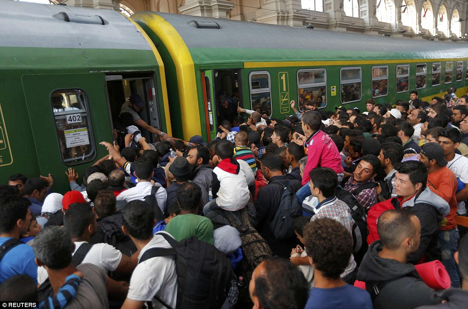 Hàng trăm người nhập cư tuyệt vọng lao lên tàu sau 2 ngày nhà ga tạm đóng cửa, gây nên cảnh tượng hỗn loạn. (Nguồn: Dailymail)
