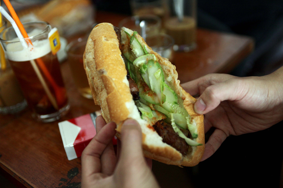Chiếc bánh mì kẹp 1, 2 xiên thịt rồi thêm chút dưa, ớt ăn nóng hổi, ngon lành từ lâu đã được rất nhiều người ưa thích. (Ảnh: Doãn Đức/Vietnam+)