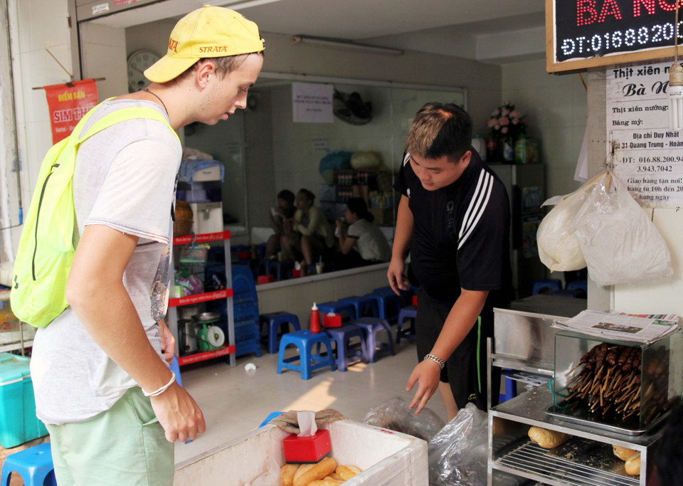 Du khách nước ngoài cũng ghé thăm nơi đây để thưởng thức món thịt xiên nướng trứ danh. (Ảnh: Doãn Đức/Vietnam+)