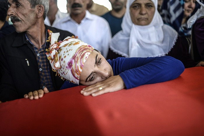 Một người phụ nữ tỏ cảm xúc đau buồn trên quan tài người thân bị thiệt mạng trong vụ đánh bom liều chết làm ít nhất 30 người thiệt mạng ở Suruc, Thổ Nhĩ Kỳ. (Nguồn: AFP)