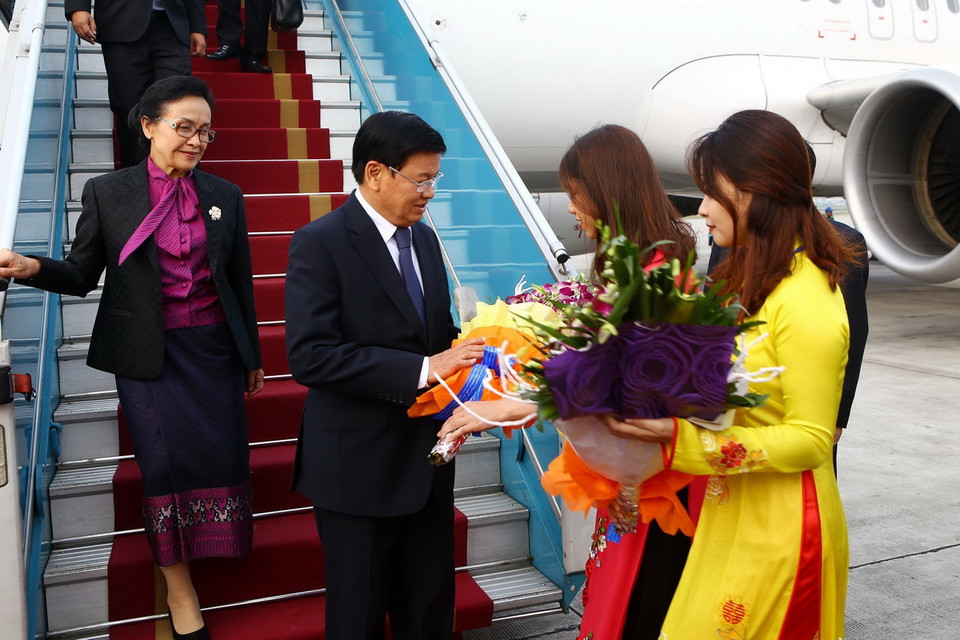 Thiếu nữ Hà Nội tặng hoa chào mừng Thủ tướng Lào Thongloun Sisoulith và Phu nhân tại sân bay quốc tế Nội Bài. (Nguồn: TTXVN)