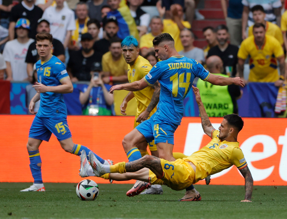 Pha tranh bóng giữa tiền vệ Georgiy Sudakov (số 14) của Ukraine với tiền vệ Marius Marin của Romania. (Ảnh: THX/TTXVN)