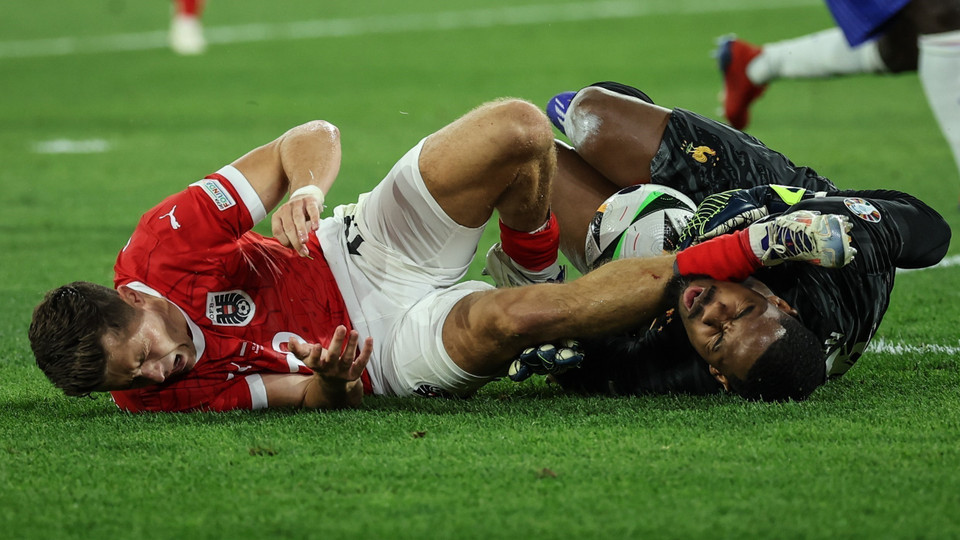 Pha va chạm giữa cầu thủ Christoph Baumgartner (trái) của Áo và thủ môn đội tuyển Pháp Mike Maignan. (Ảnh: THX/TTXVN)