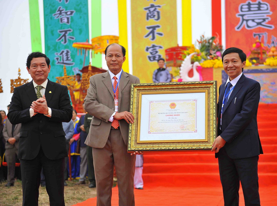 Thứ trưởng Bộ Văn hóa, Thể thao và Du lịch Huỳnh Vĩnh Ái (bên trái) trao bằng công nhận Lễ Tịch điền Đọi Sơn là di sản văn hóa phi vật thể quốc gia cho đại diện tỉnh Hà Nam. (Ảnh: Minh Đức/TTXVN)