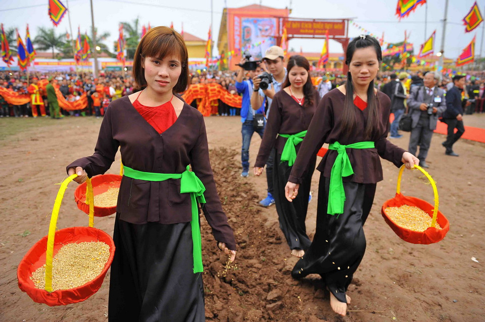 Các thôn nữ gieo hạt để cầu mong một năm mới mùa màng tốt tươi tại lễ hội. (Ảnh: Minh Đức/TTXVN)