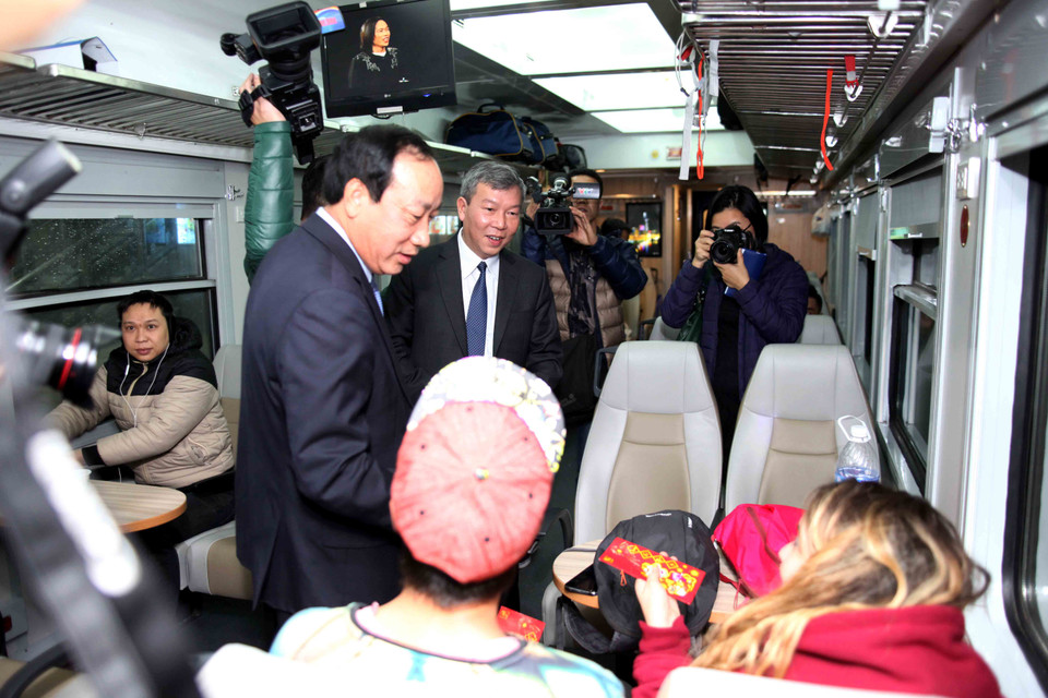 Thứ trưởng lì xì cho các hành khách trên chuyến tàu. (Ảnh: Doãn Đức/Vietnam+)