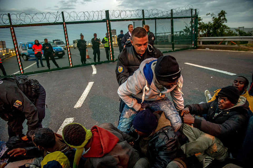 Cảnh sát Pháp cố gắng chia cắt, kiểm soát những người di cư bất hợp pháp tại khu vực Coquelles gần Calais. (Nguồn: AFP)