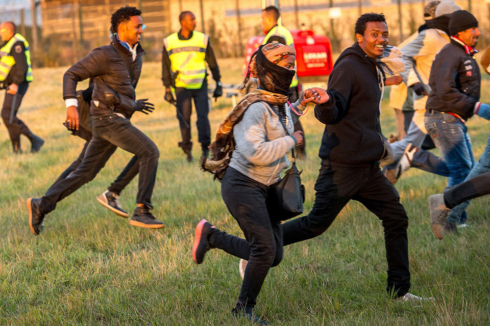 Những người di cư tỏ ra vui mừng khôn xiết khi họ vượt qua cảnh sát để tiếp cận đường ray Coquelles gần Calais. (Nguồn: AFP)