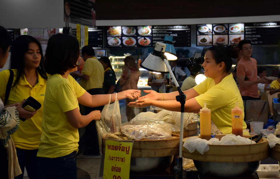 Trong những ngày này, hầu hết người dân Thái Lan đều mặc áo vàng để thể hiện lòng tôn kính với Nhà Vua. (Ảnh: Sơn Nam/Vietnam+)