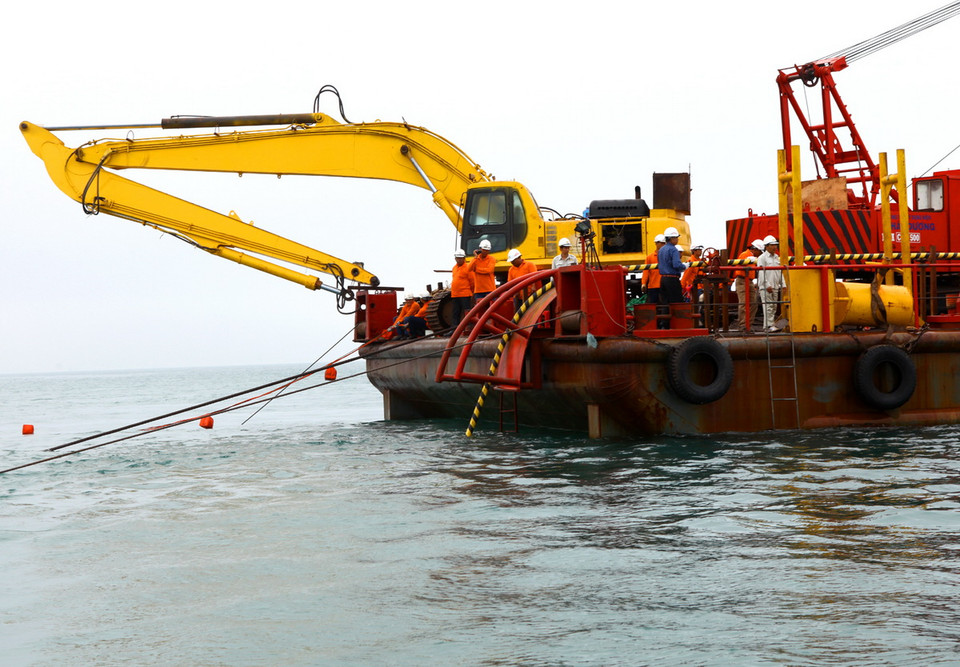 Giai đoạn thả cáp ngầm đang được triển khai từ đảo vào đất liền. (Ảnh: Ngọc Hà/TTXVN)