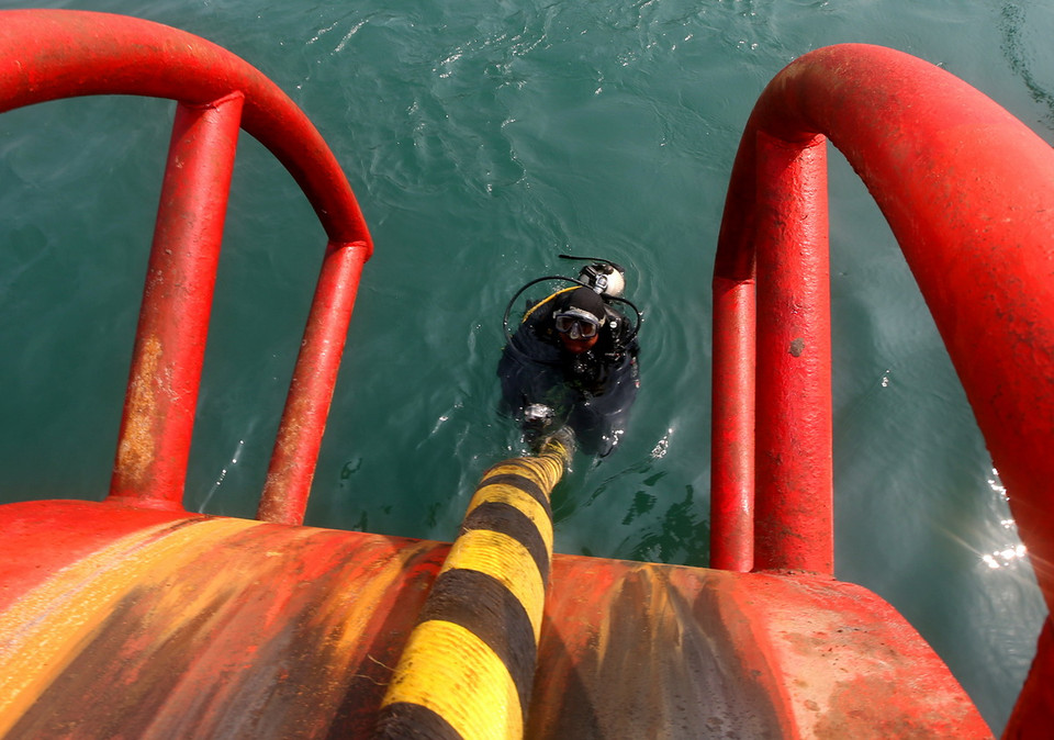 Thợ lặn kiểm tra kỹ thuật việc chôn rải cáp ngầm từ đảo vào đất liền. (Ảnh: Ngọc Hà/TTXVN) 