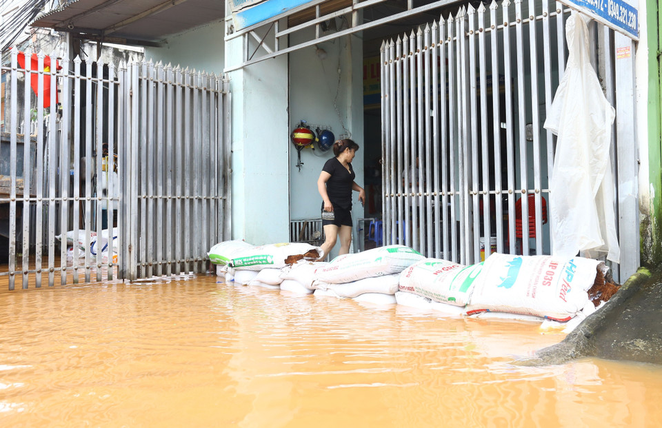 Người dân phường Phước Tân (thành phố Biên Hòa - Đồng Nai) chủ động ngăn nước lũ chảy vào nhà. (Ảnh: Lê Xuân/TTXVN)