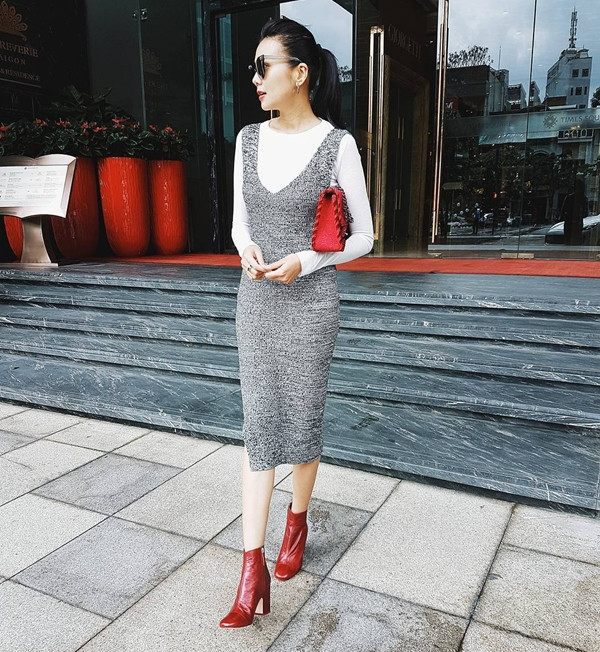 Trời trở lạnh, Thanh Hằng đã nhanh chóng chưng diện áo thun dài tay kết hợp cùng đầm len ôm sát, tôn dáng. Siêu mẫu mix khéo léo trang phục với bốt cao gót và túi cùng tông màu đỏ rực rỡ, nhấn nhá phong cách sành điệu.