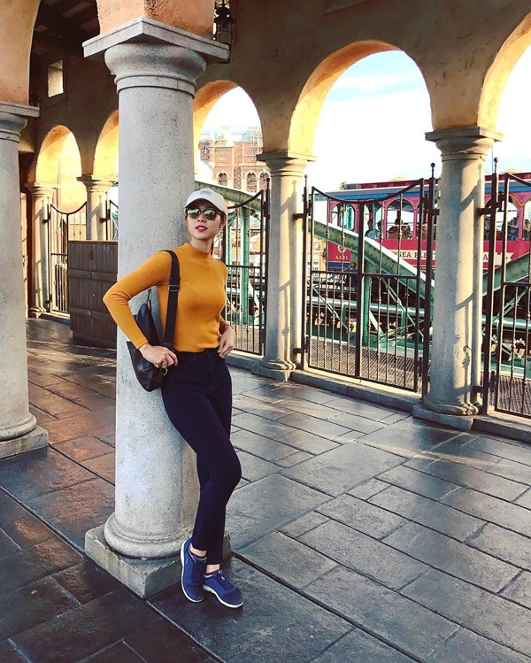 Diệp Bảo Ngọc "tô màu" cho "sàn diễn đường phố" bằng trang phục phối màu đẹp mắt. Người đẹp bắt cặp quần skinny đen cùng áo màu vàng nghệ, tạo hiệu ứng tương phản, thu hút sự chú ý.