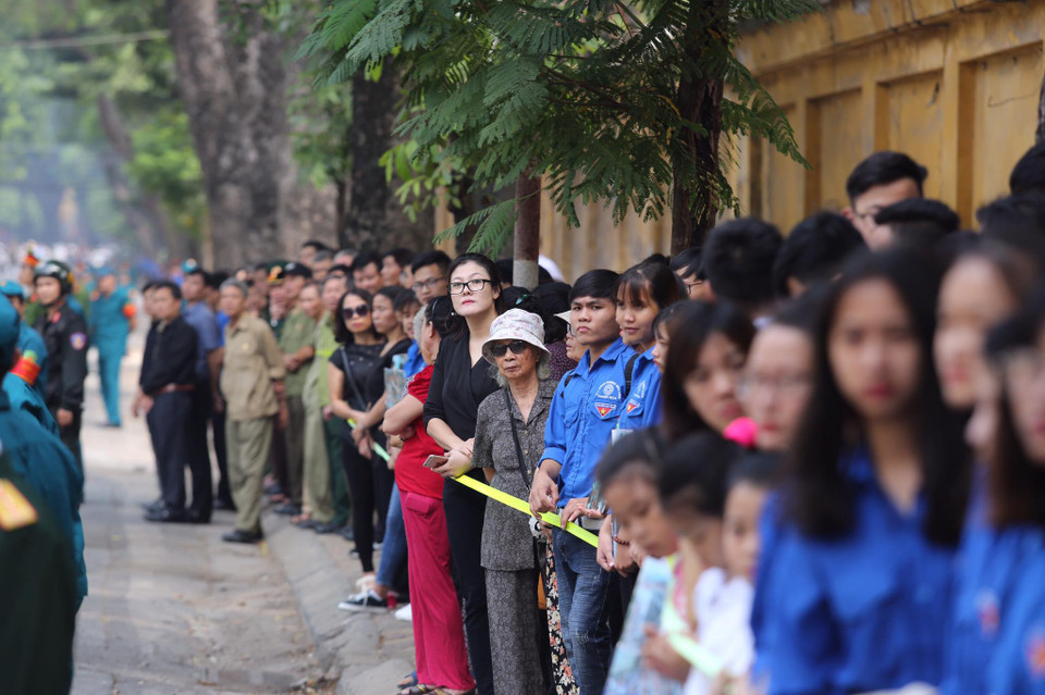 Các em học sinh trường THCS Nguyễn Tri Phương đưa tiễn linh cữu nguyên Tổng Bí thư Đỗ Mười trên phố Hoàng Diệu (Hà Nội). (Ảnh: Thành Đạt/TTXVN)