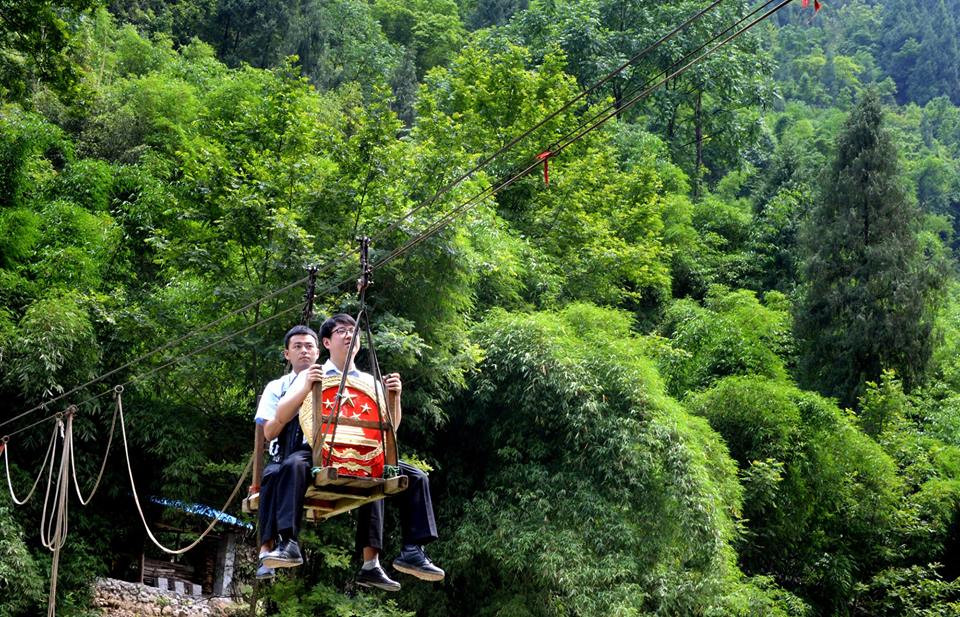 Những bức ảnh đứng tim này được chụp vào ngày 9/6 ở làng Huilong cho thấy cách hai thẩm phán này di chuyển ở vùng núi nguy hiểm. Người ngồi đằng trước đang cầm quốc huy Trung Quốc, một trong những biểu tượng xuất hiện ở tòa án. (Nguồn: CCTVNews)
