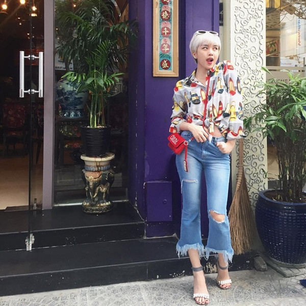 Thiều Bảo Trang phá cách cùng sơmi vintage buộc vạt, mix cùng quần jeans lửng ống loe, không quên nhấn nhá cảm hứng mới mẻ bằng túi đeo nhỏ xinh màu đỏ rực.