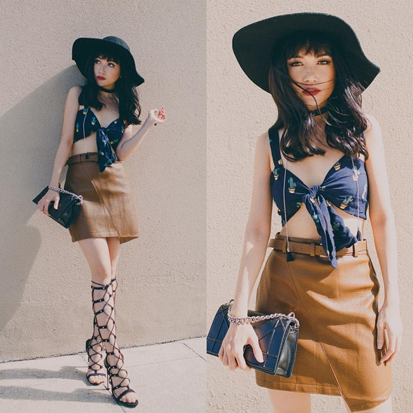 Sĩ Thanh 'thắp sáng' phong cách đường phố cùng bộ đồ hơi hướng boho chic. Cô phối chân váy ngắn màu camel với crop top dáng nội y lạ mắt. Vòng cổ choker, mũ vành tròn và sandals chiến binh đều là những phụ kiện hỗ trợ đắc lực, tạo nét chấm phá cho tổng thể trang phục.