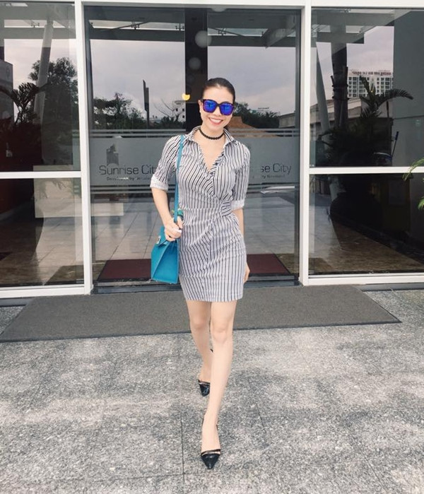 Diện đầm liền kẻ sọc tôn vóc dáng nuột nà, người đẹp Trà Ngọc Hằng chọn phụ kiện nhấn là túi đeo gam màu sáng, làm tăng nét rạng rỡ. 