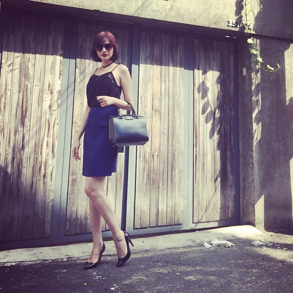 Trúc Diễm phối áo hai dây cùng chân váy bút chì nhã nhặn. Người đẹp hoàn thiện vẻ ngoài sang trọng bằng đôi giày cao gót đen và túi xách tiệp màu.